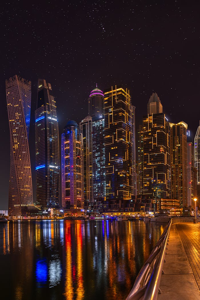 Explore the dazzling skyline of Dubai Marina at night, reflecting on calm waters.